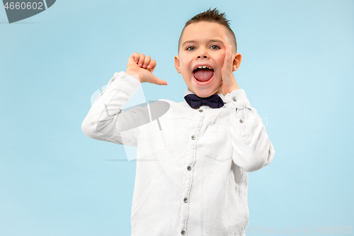 Image of Isolated on blue young casual boy shouting at studio