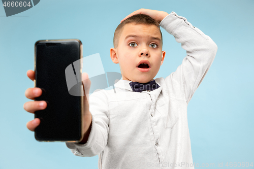 Image of Indoor portrait of attractive young boy holding blank smartphone