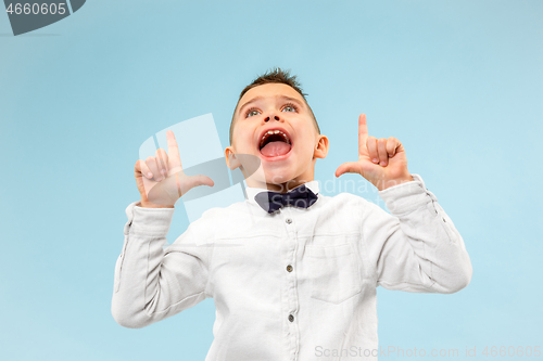 Image of Isolated on blue young casual boy shouting at studio