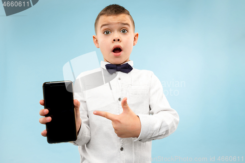 Image of Indoor portrait of attractive young boy holding blank smartphone