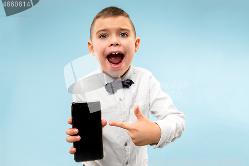 Image of Indoor portrait of attractive young boy holding blank smartphone