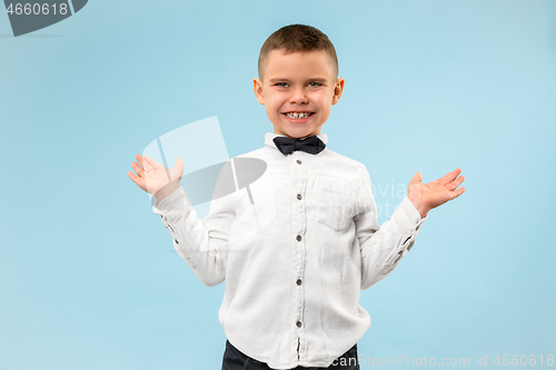 Image of The happy teen boy standing and smiling against blue background.