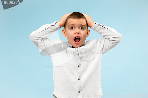 Image of The young attractive teen boy looking suprised isolated on blue