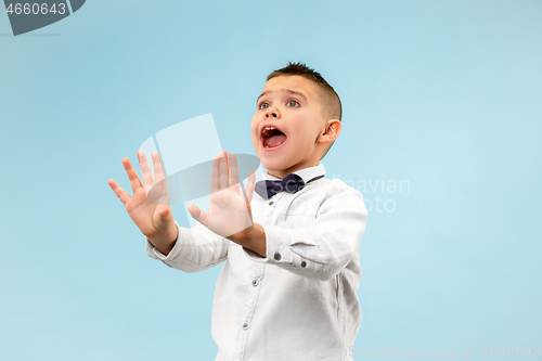 Image of Portrait of the scared teen boy on blue