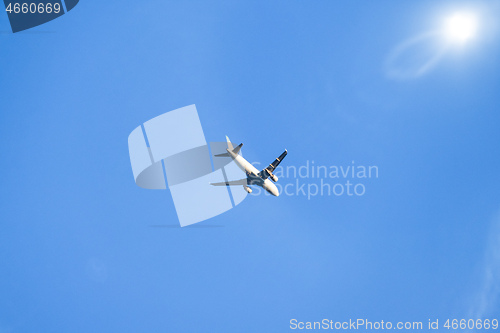 Image of blue sky with plane and sun