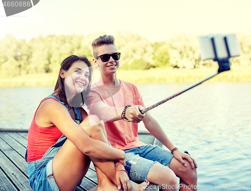 Image of happy teenage couple taking selfie on smartphone