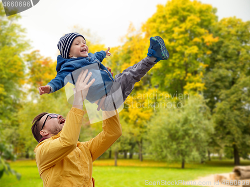 Image of father with son playing and having fun in autumn