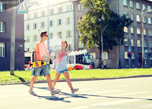 Image of teenage couple with skateboards on city street