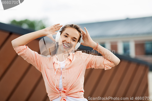 Image of happy teenage girl with headphones in city