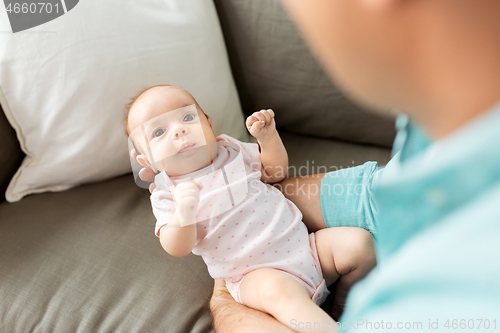 Image of middle aged father with baby daughter at home