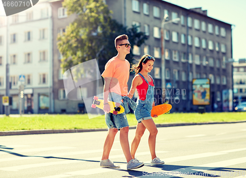 Image of teenage couple with skateboards on city street