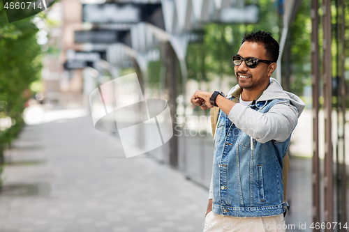 Image of indian man recording voice message by smart watch