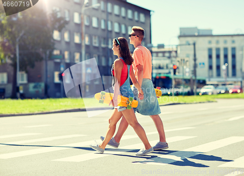 Image of teenage couple with skateboards on city crosswalk