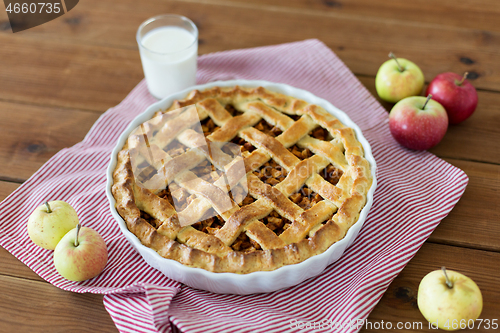 Image of apple pie in baking mold on wooden table