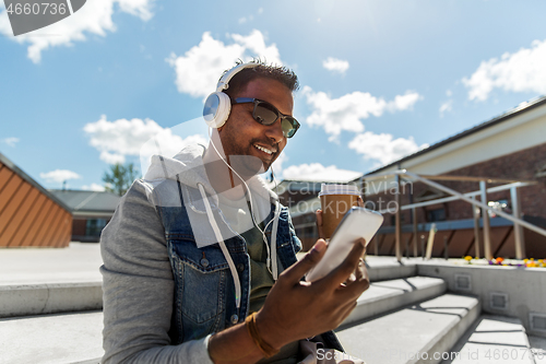 Image of man with smartphone and headphones on roof top