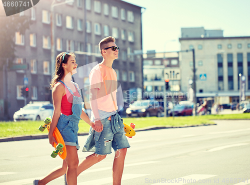 Image of teenage couple with skateboards on city street