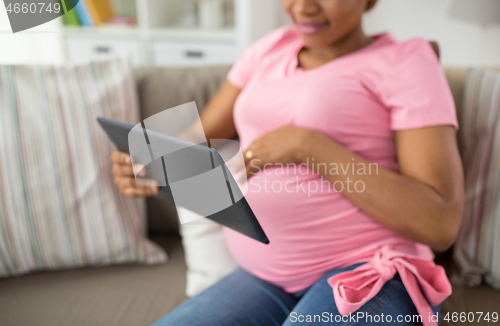 Image of close up of pregnant woman with tablet pc at home