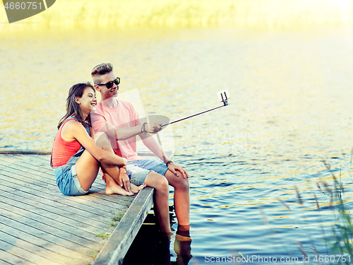 Image of happy teenage couple taking selfie on smartphone