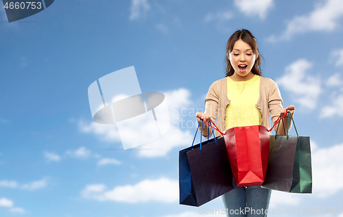 Image of happy asian woman with shopping bags