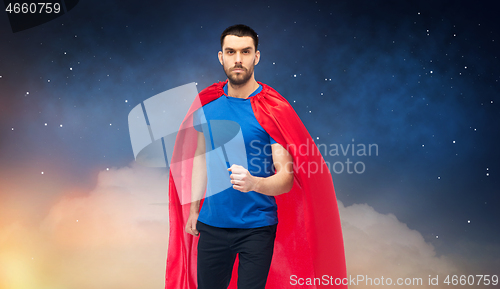 Image of man in red superhero cape over night sky