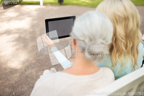 Image of adult daughter and senior mother with tablet pc