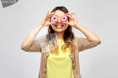 Image of happy asian woman with eyes of donuts