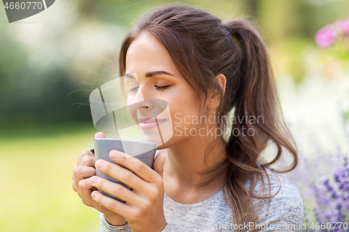 Image of woman drinking tea or coffee at summer garden