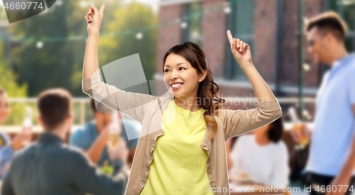 Image of happy asian woman dancing over rooftop party