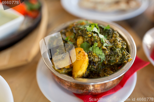 Image of close up of aloo palak dish in bowl on table