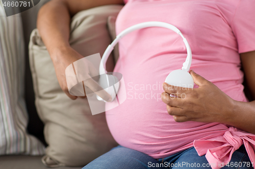 Image of pregnant woman with headphones on her belly