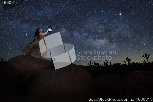 Image of Girl Holding Lantern in the Desert Under the Milky Way