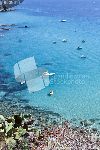 Image of Boats near a rock stone coast. Scenic view of tipycal rocky coas