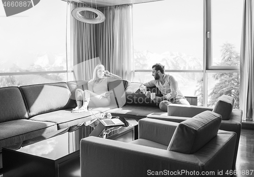 Image of couple relaxing at  home using tablet computer