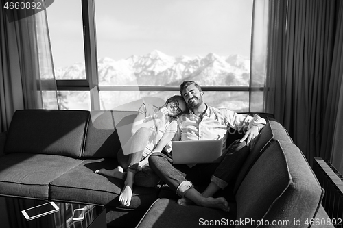 Image of couple relaxing at  home using laptop computers