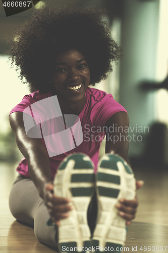 Image of woman in a gym stretching and warming up before workout