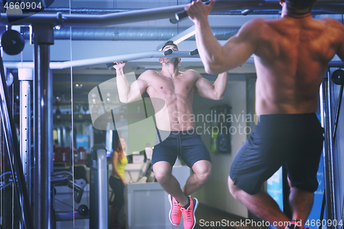 Image of handsome man exercising at the gym