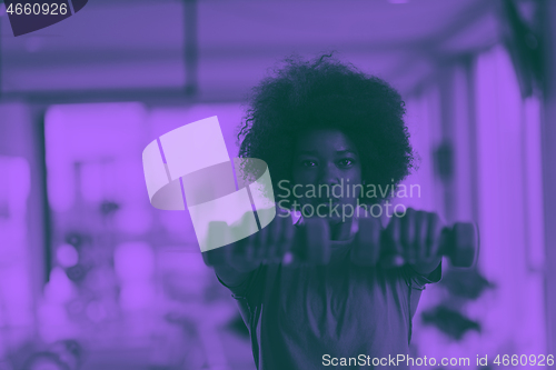 Image of woman working out in a crossfit gym with dumbbells