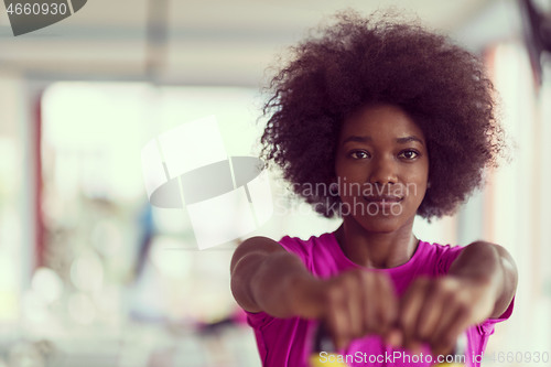 Image of woman working out in a crossfit gym with dumbbells