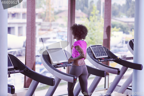 Image of afro american woman running on a treadmill