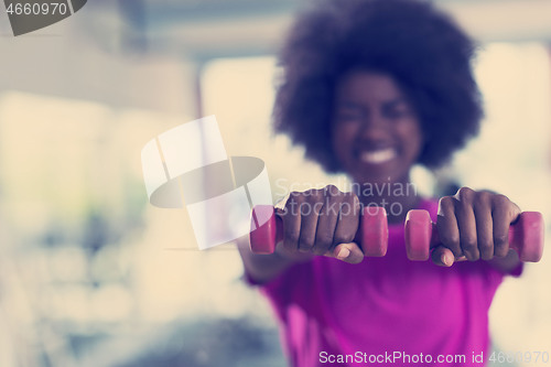 Image of woman working out in a crossfit gym with dumbbells