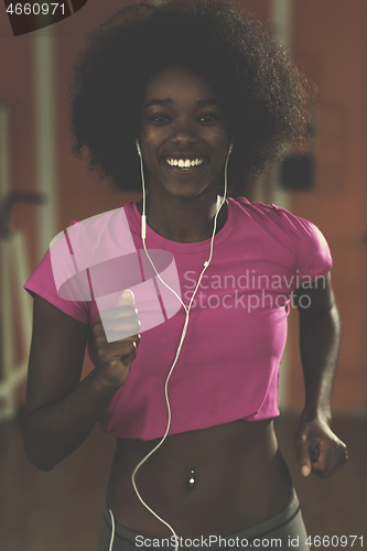 Image of afro american woman running on a treadmill