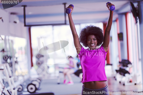 Image of woman working out in a crossfit gym with dumbbells