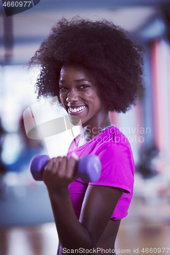 Image of woman working out in a crossfit gym with dumbbells