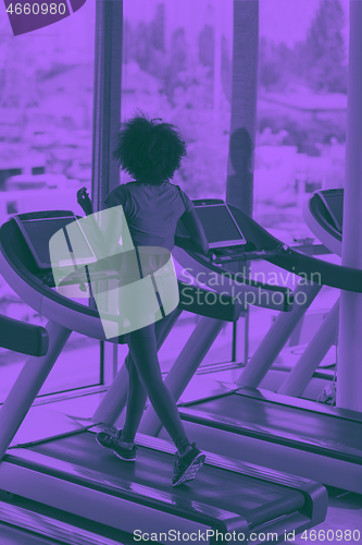 Image of afro american woman running on a treadmill