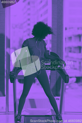 Image of afro american woman running on a treadmill