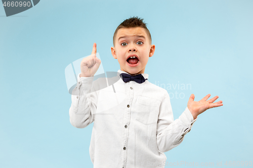 Image of The young attractive teen boy looking suprised isolated on blue