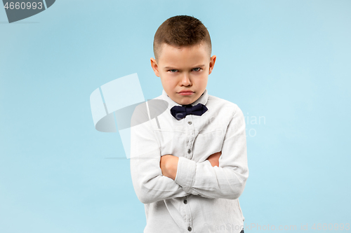 Image of The young emotional angry teen boy on blue studio background