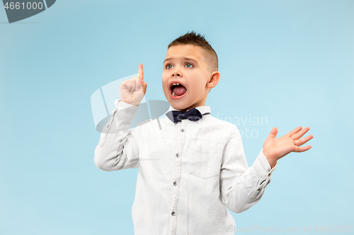 Image of The young attractive teen boy looking suprised isolated on blue