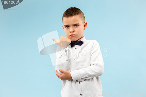 Image of The teen boy whispering a secret behind her hand over blue background