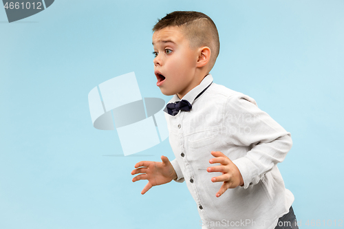 Image of The young attractive teen boy looking suprised isolated on blue